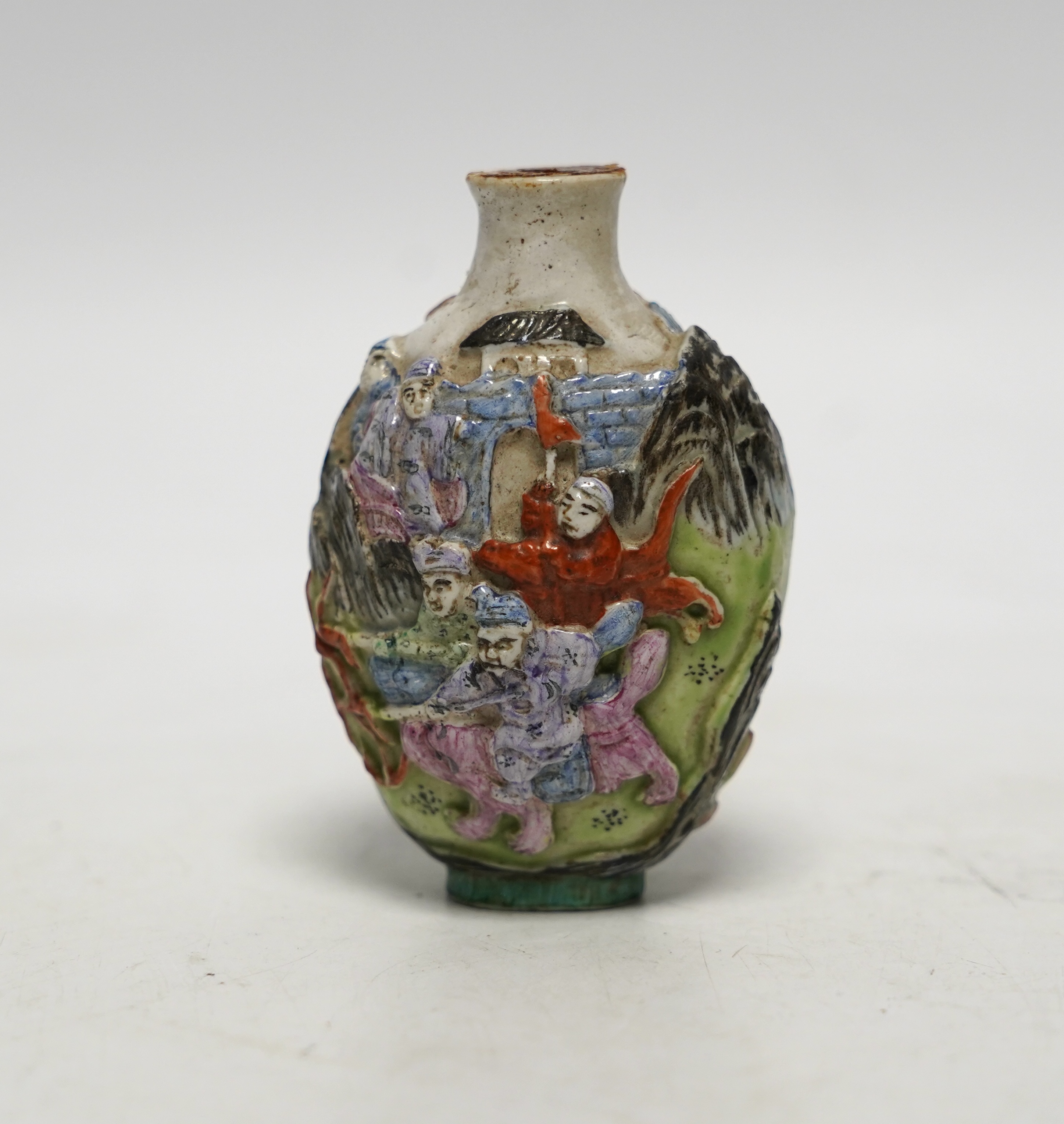 A Chinese moulded in enamelled porcelain ‘figures riding mythical beasts’ snuff bottle, Qianlong mark, 19th century, 8.5cm high